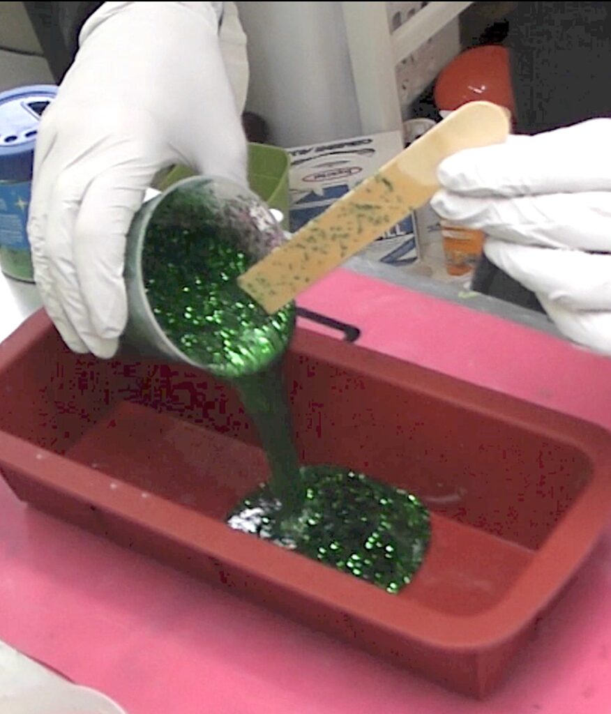 pour green glitter resin into silicone loaf mold
