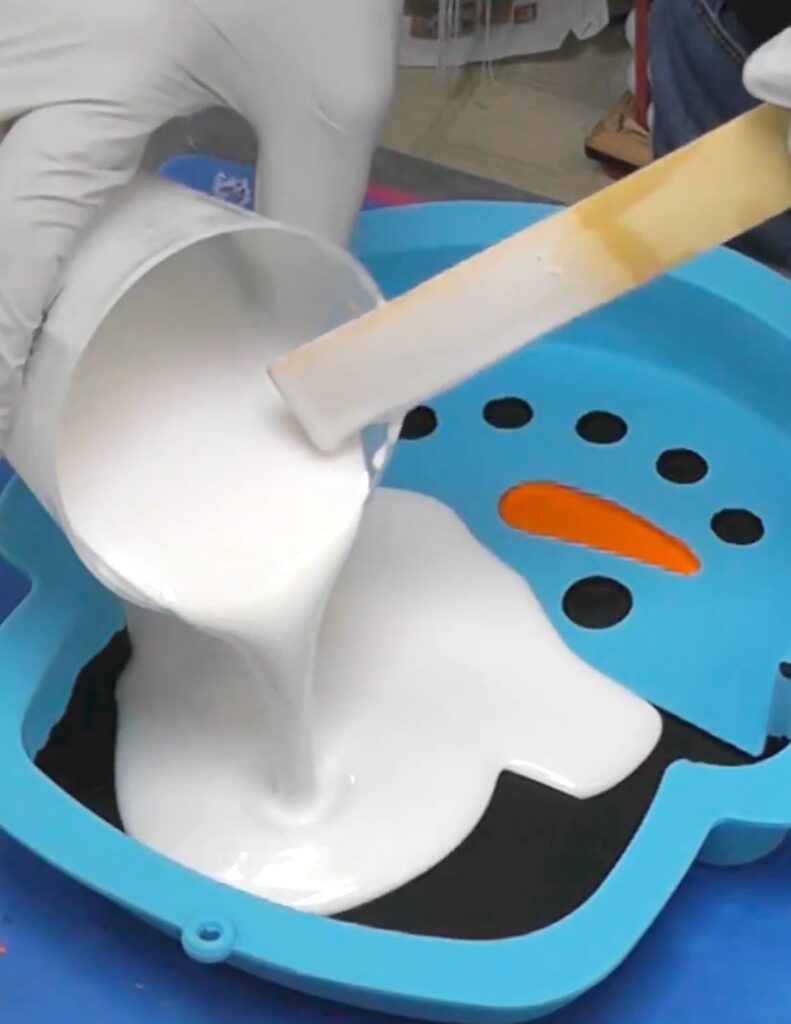 Pouring white resin into the big snowman decoration DIY mold