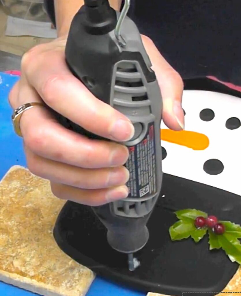Using a dremel to drill a hole into the snowman diy