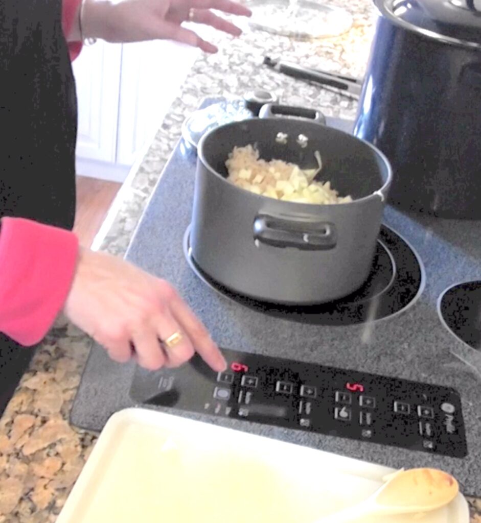 Sauerkraut, onions, apples and bacon in cooking pot on stove