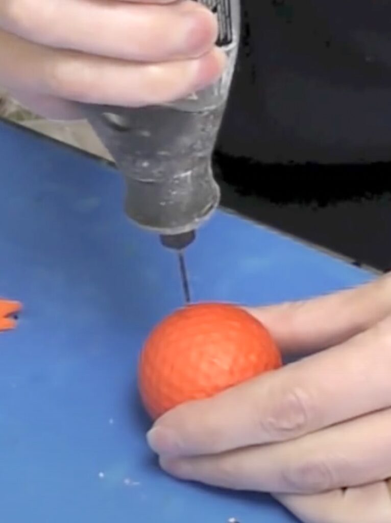 Drill hole into orange golf ball