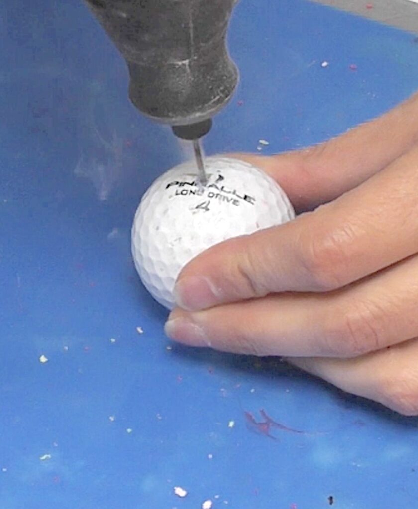 Drill hole into golf ball