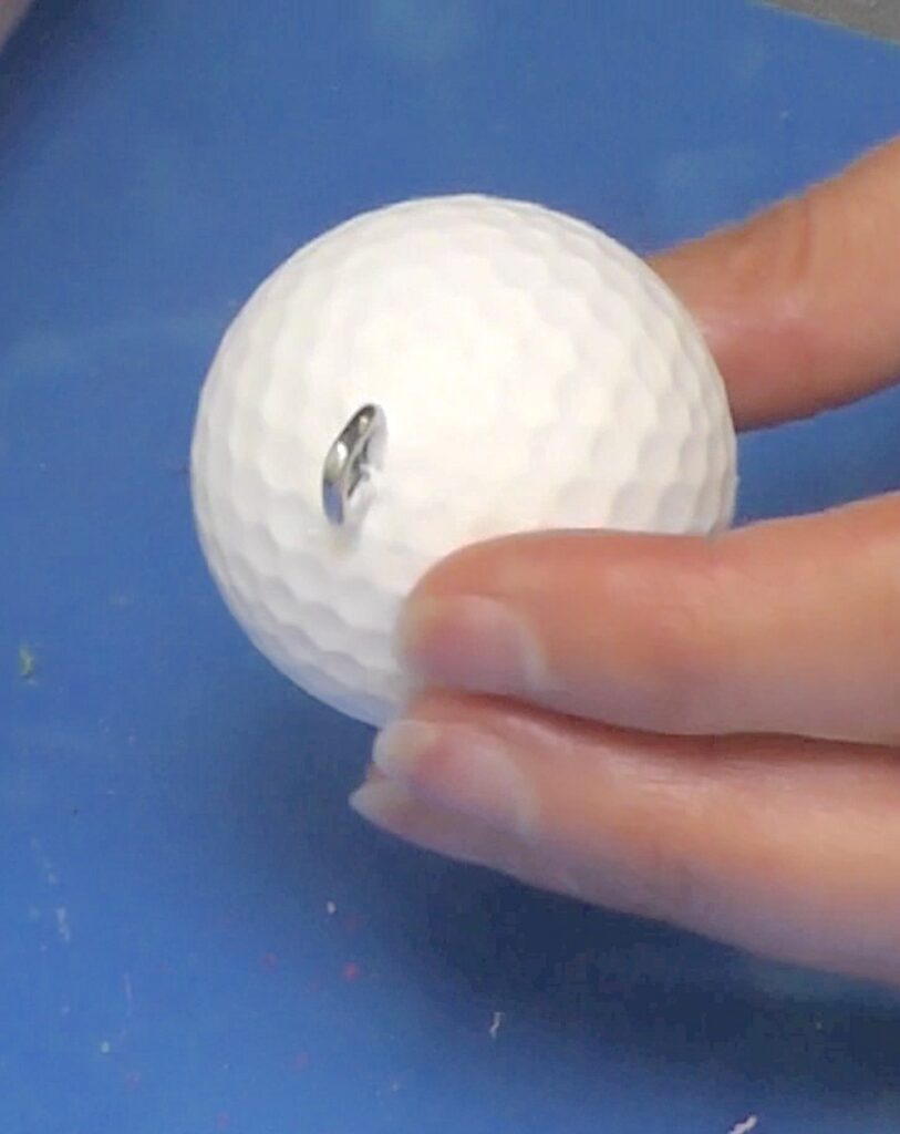 Holding golf ball painted white