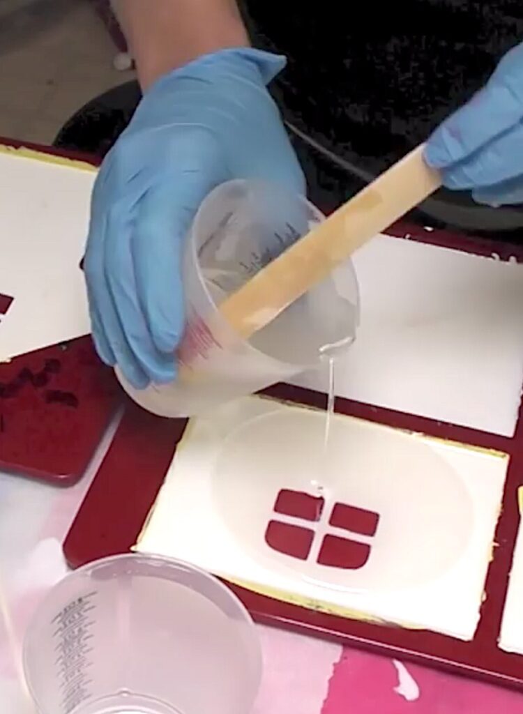 Pouring clear resin in the easter bunny house craft to create the windows