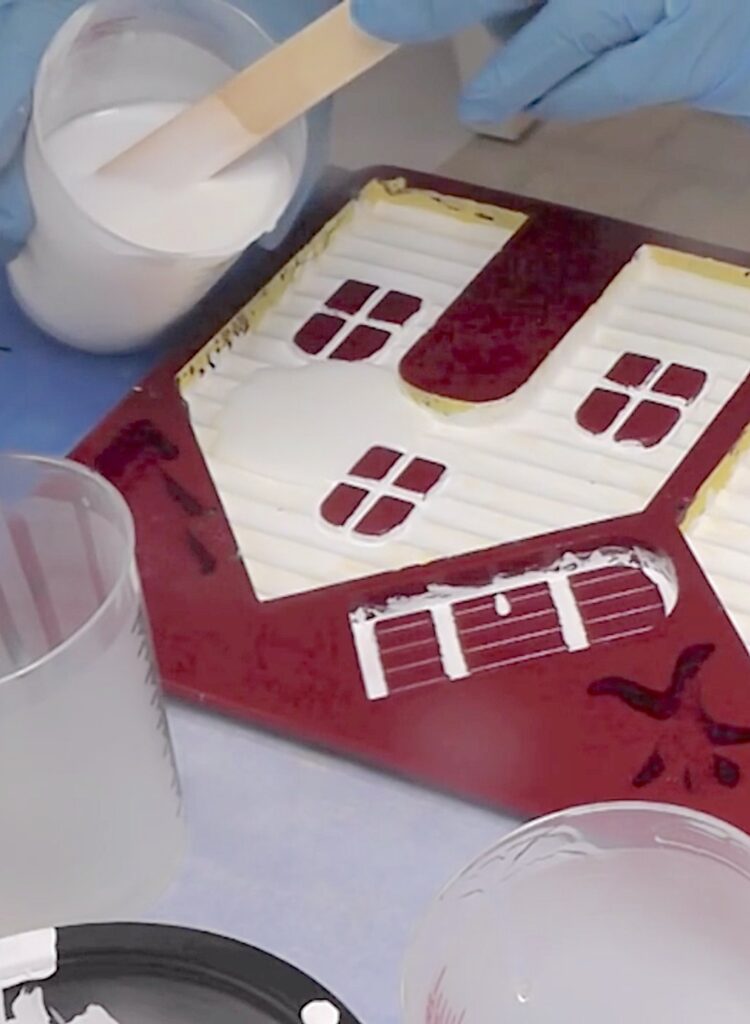 Pouring white resin into the mold for the walls