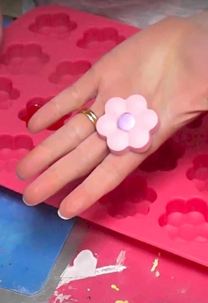 resin pink spring flower with purple center in hand