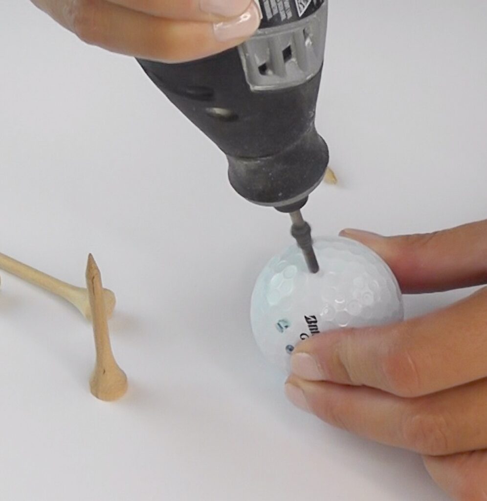 Drill hole into golf ball