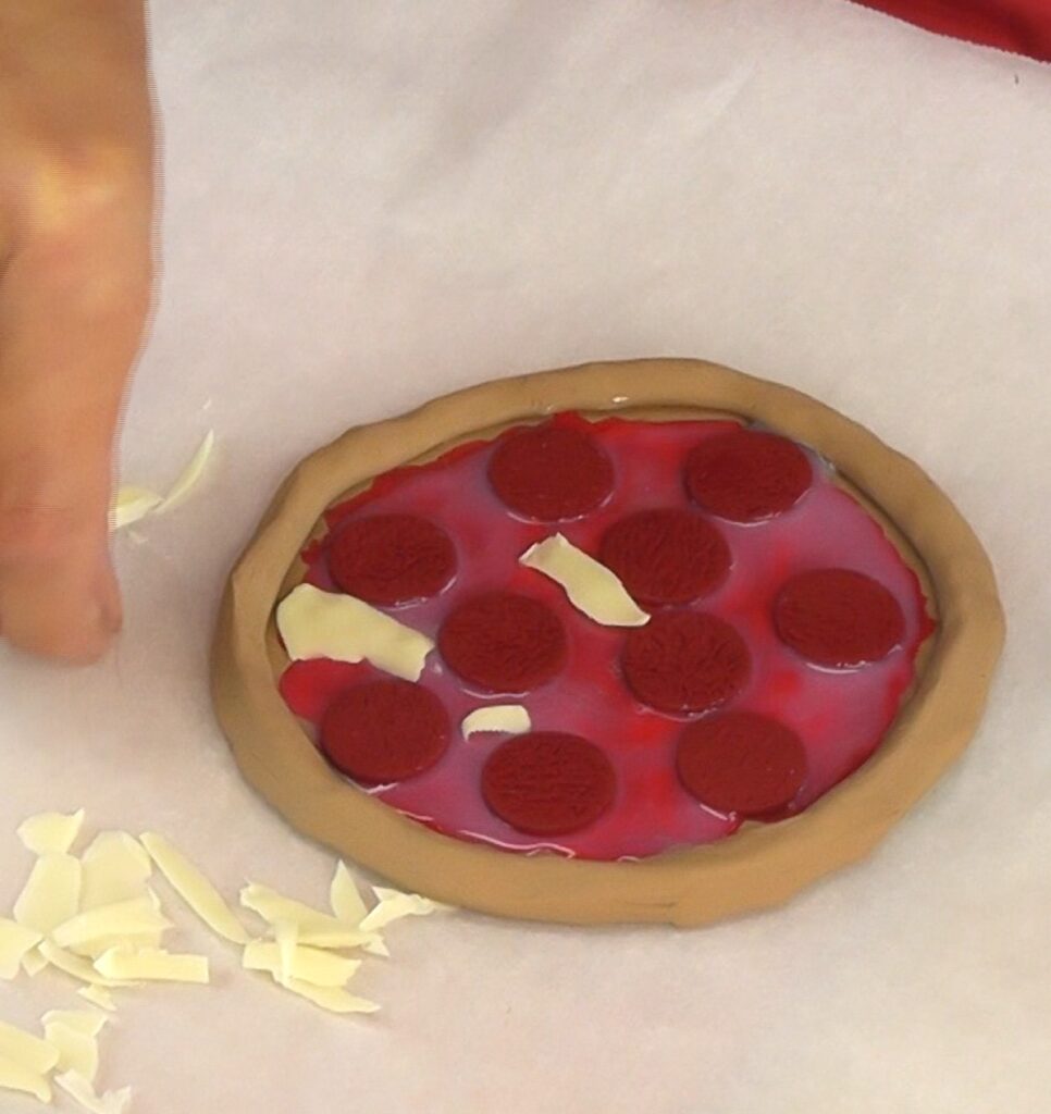 Add the pepperoni and the clay cheese to the DIY pizza craft