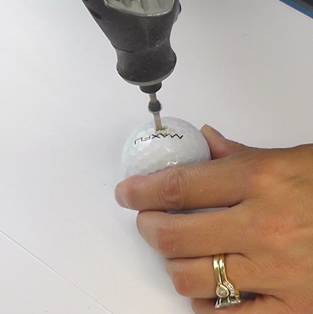 Drill hole in golf ball with rotary tool