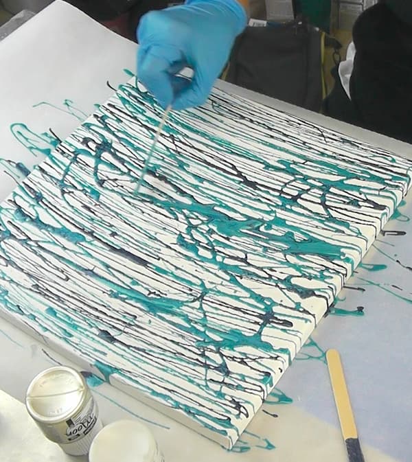 How to make mermaid mixed media art DIY | adding blue and purple streaks of paint to make the mermaid mixed media background