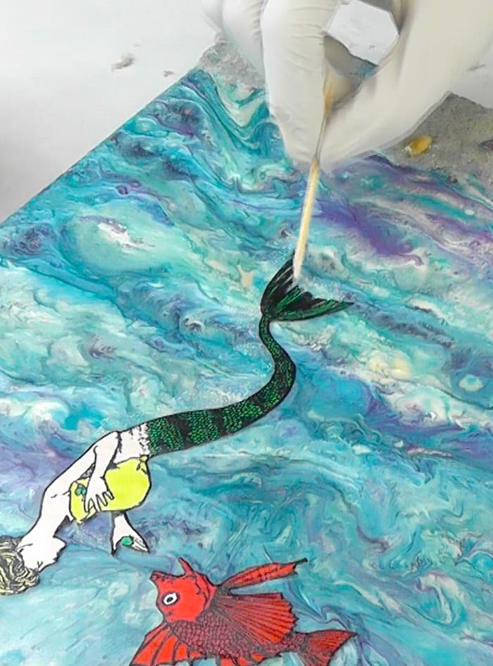 Adding glitter to the mermaid tail with a toothpick