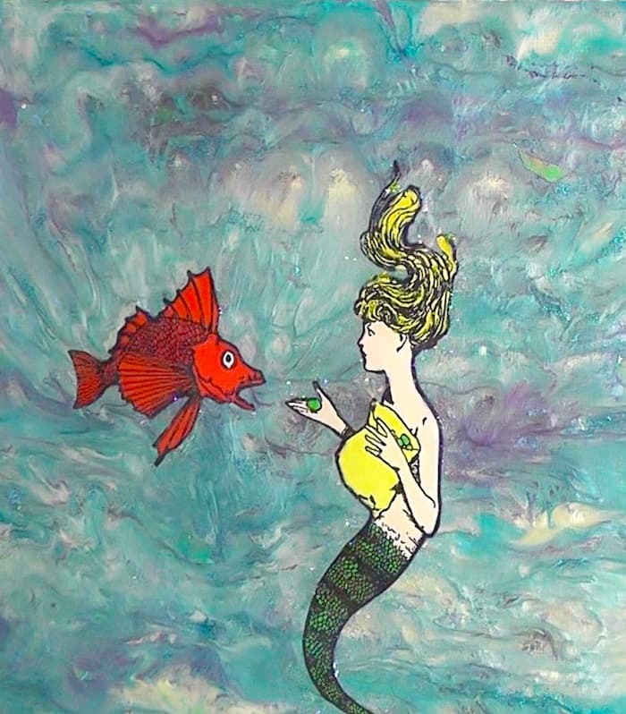 Close up of mermaid mixed media art with mermaid feeding orange fish