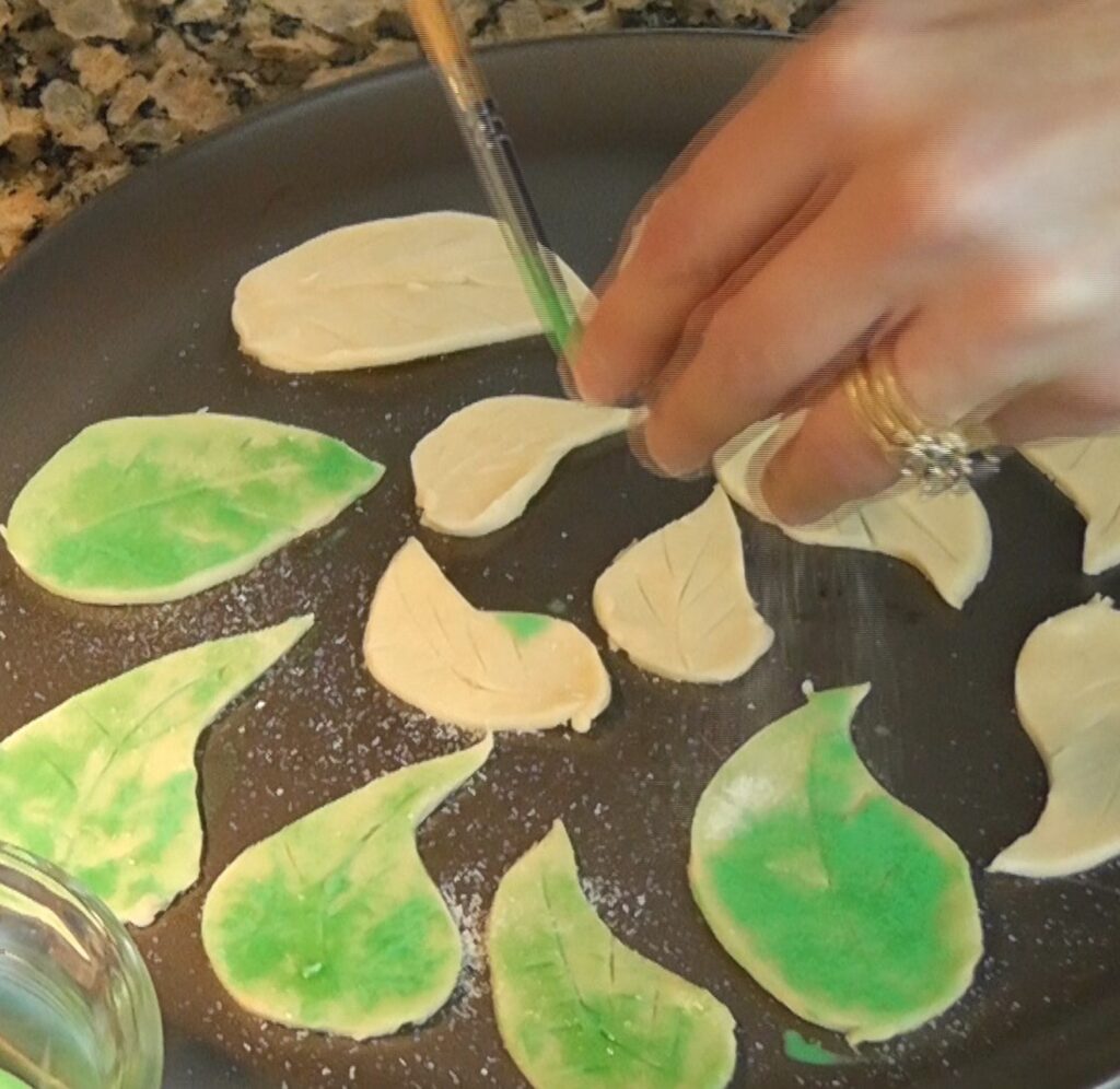 Sprinkling sugar on dough leaves