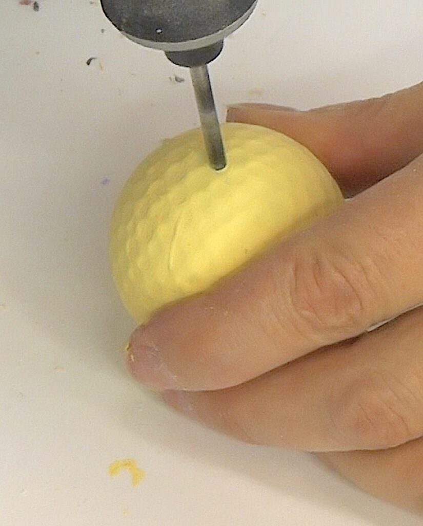 Drill hole into the golf ball large enough for a skewer stick