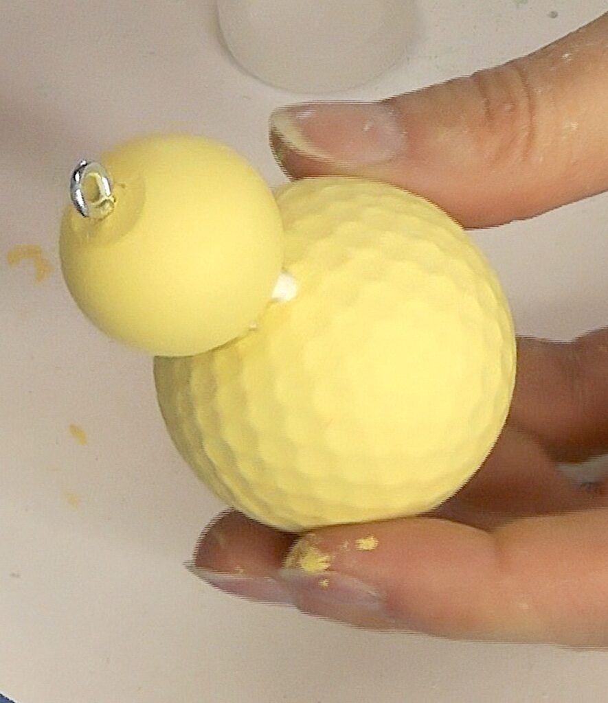 Yellow golf ball with dowel cap glued on and eyescrew