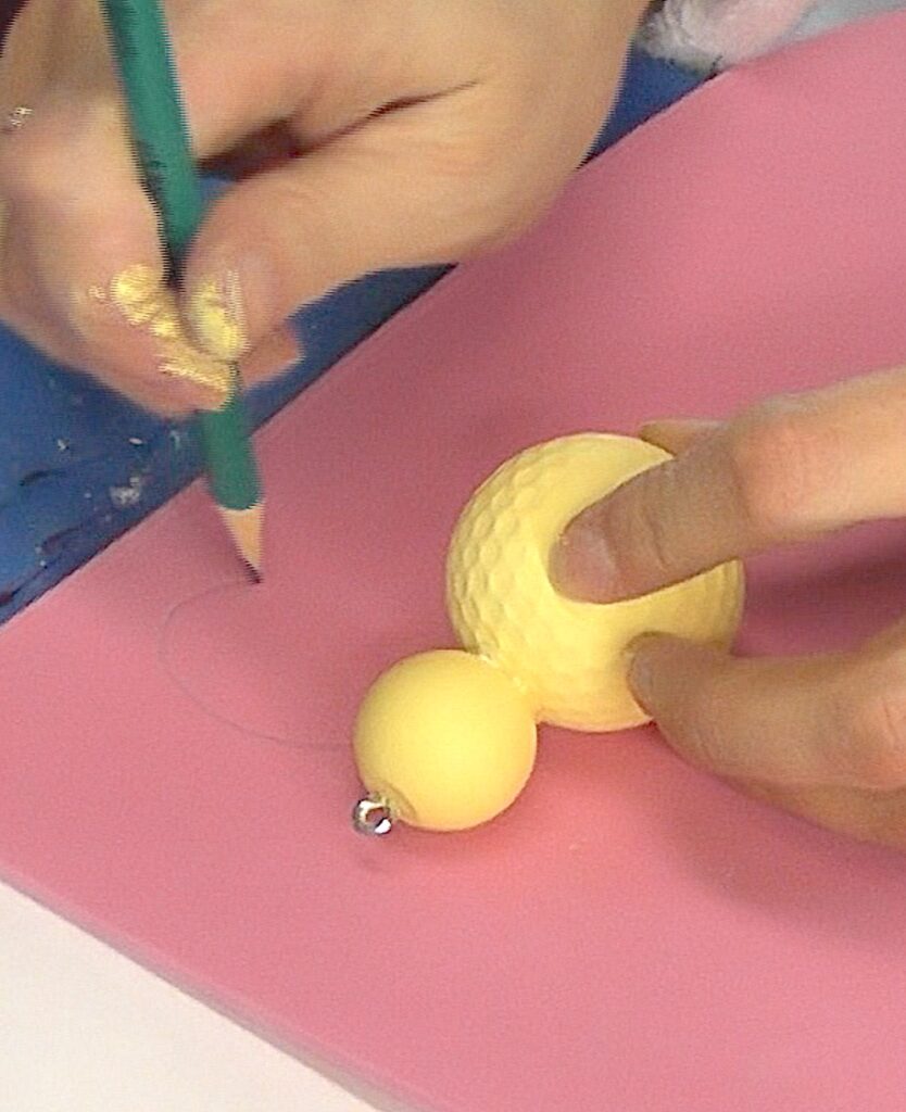 Lay golf ball on pink craft foam and draw butterfly wings