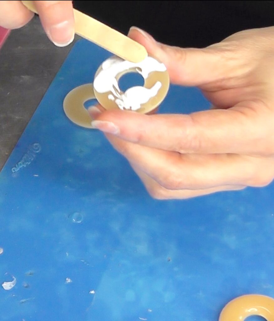 Smear glue onto donut halves to make donut necklaces