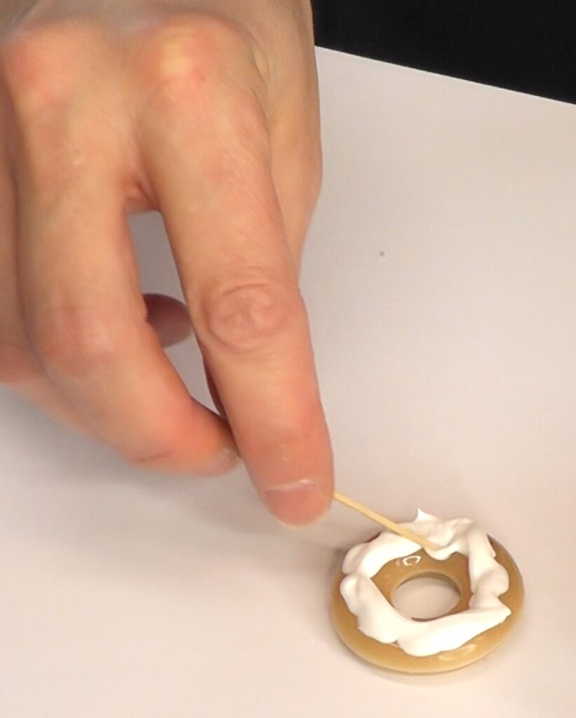 Use a toothpick to move the frosting around the donut