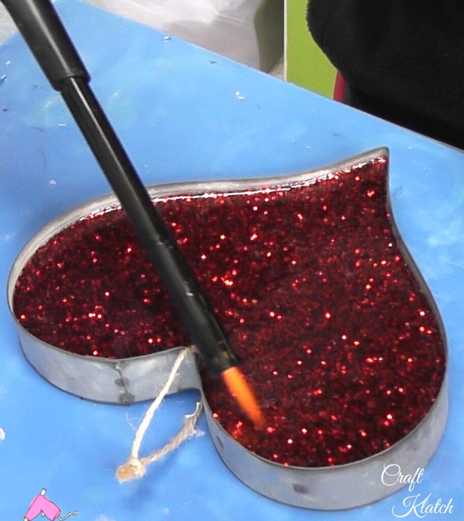 Use lighter to pop bubbles in the resin heart