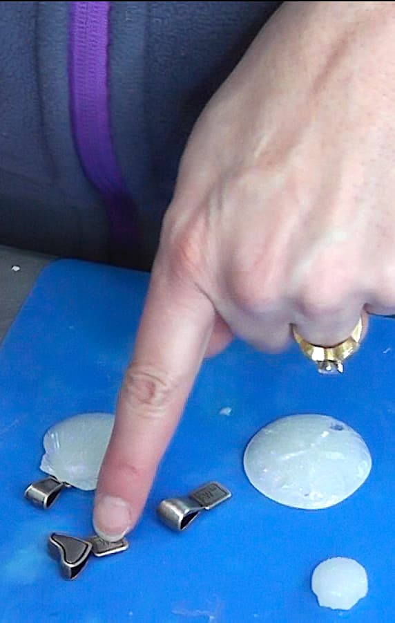 Pointing at the jewelry bail with a heart