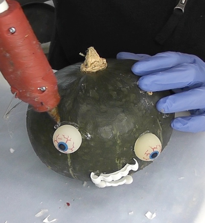 Use hot glue to build up around eyeballs on Halloween painted pumpkins