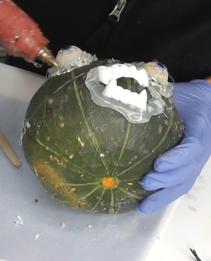 building up hot glue around the eyes of the Halloween painted pumpikins