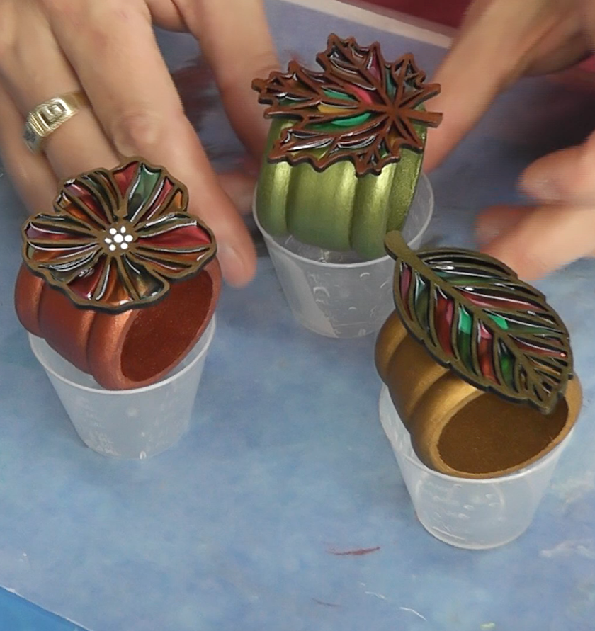 Gluing the resin fall leaves to the Thanksgiving craft napkin rings 