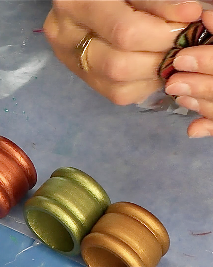 Pulling packing tape off of the back or the wood flower for the napkin rings