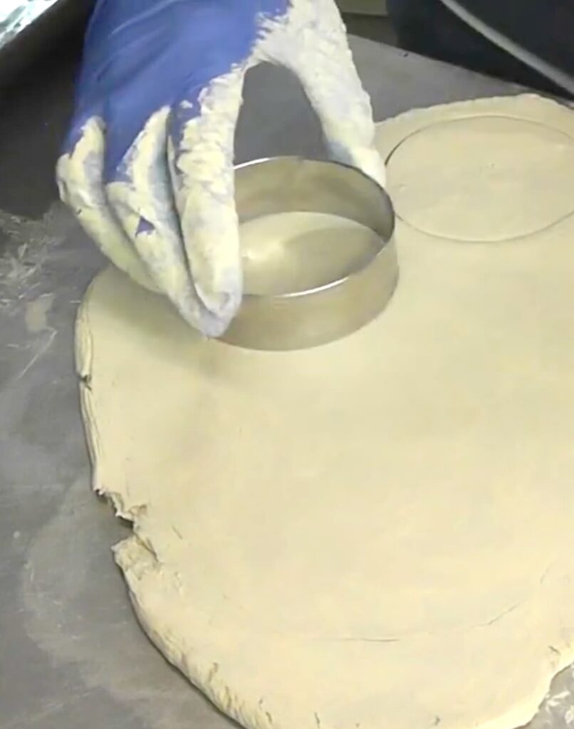Using a cookie cutter on paper clay that has been rolled out for the easy sugar cookie coasters DIY