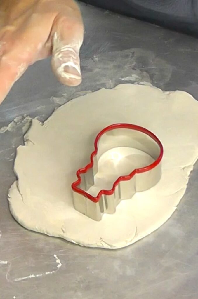 Using a snowman cookie cutter to make easy sugar cookies