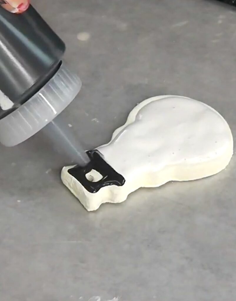 Using a squeeze bottle to add icing to cookie