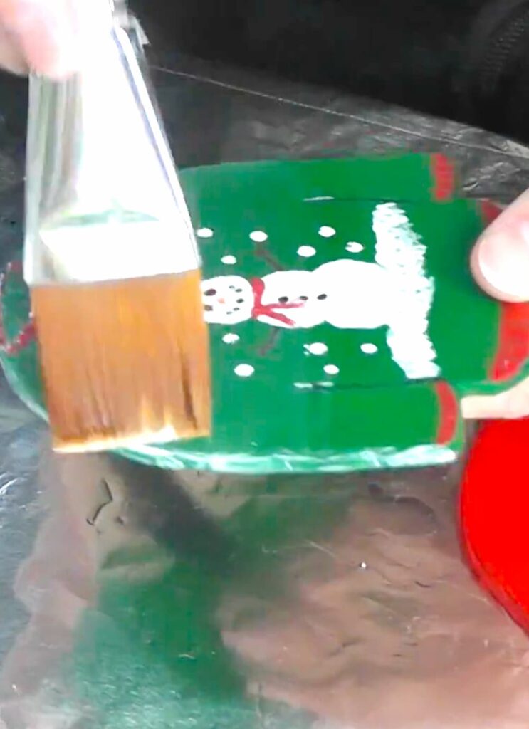 Brushing Mod Podge over the ugly Christmas sweater