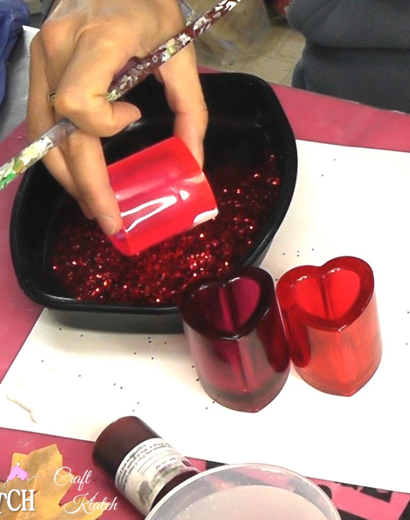Dip glue into chunky red glitter