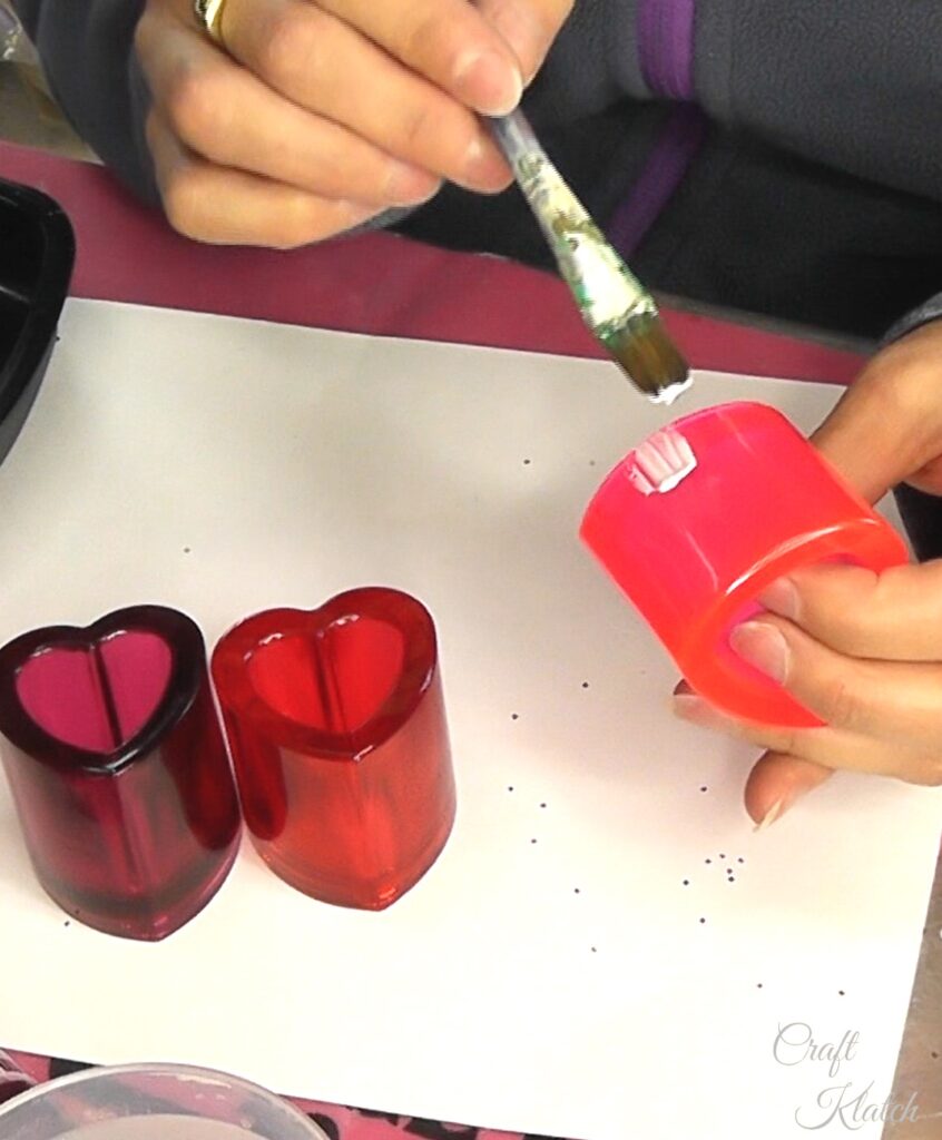 Brush glue onto lower part of resin heart