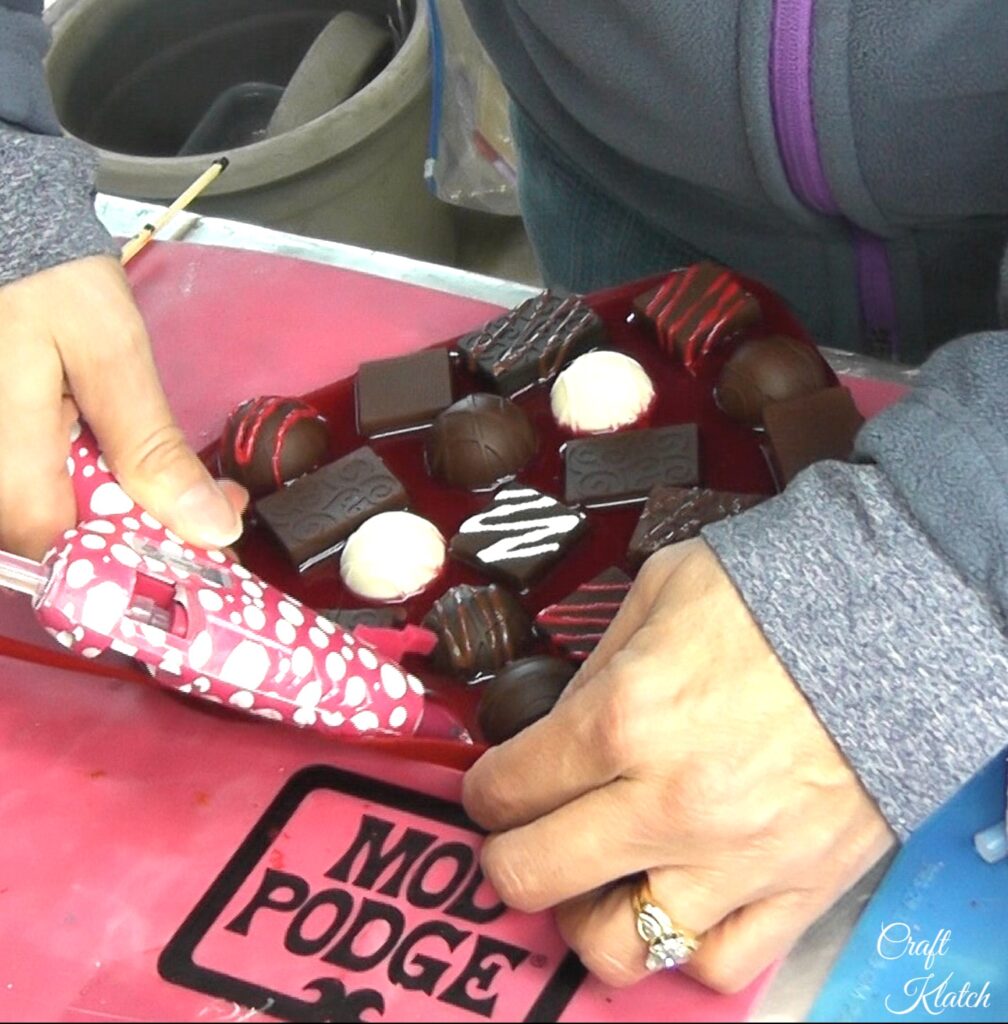 Use glue gun to glue red felt strip to candy box