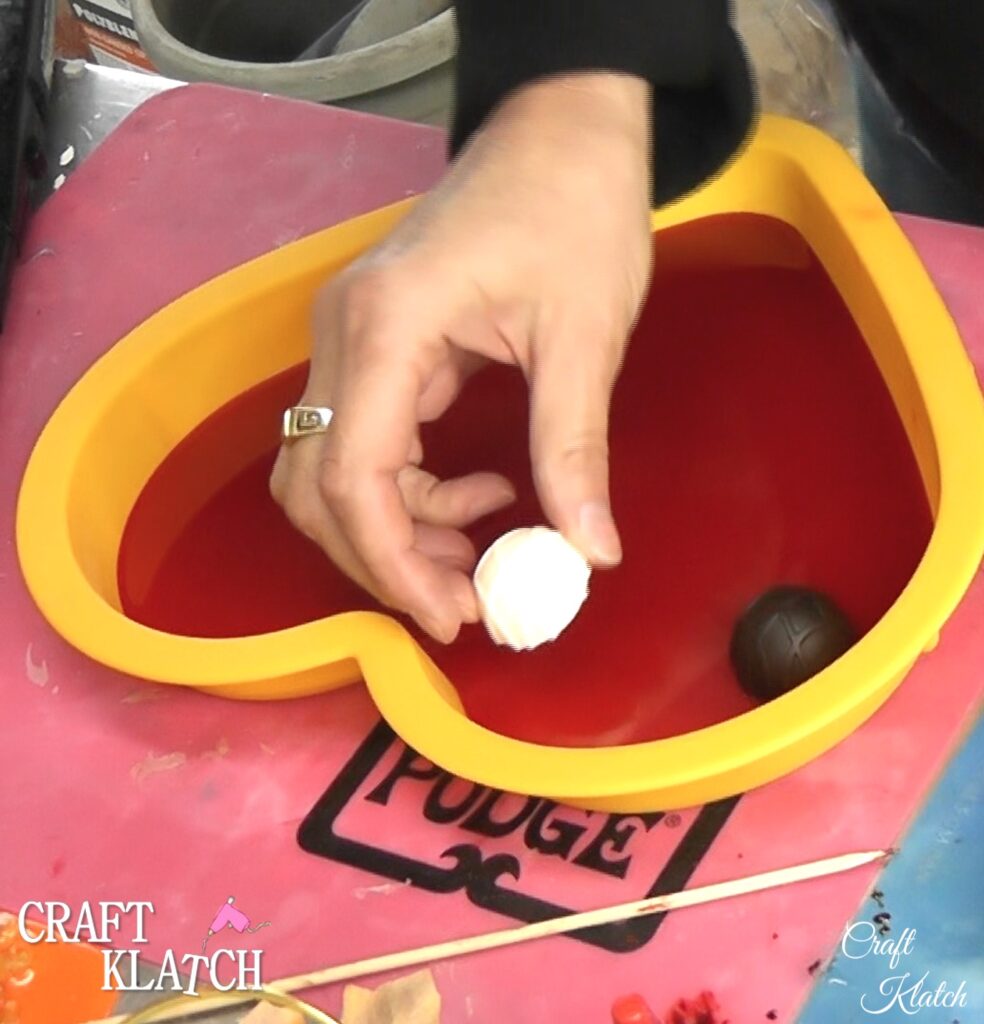 Use lighter to pop bubbles in resin in chocolate mold