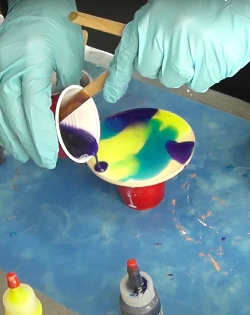 Pouring different colors on the resin coaster for the abstract art