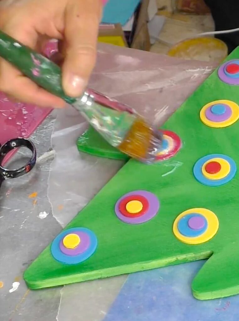 Adding a glossy finish to the whimsical Christmas tree