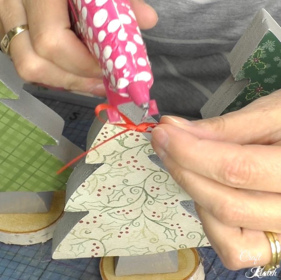 Hot glue bow onto top of wood scrapbook paper Christmas tree diy