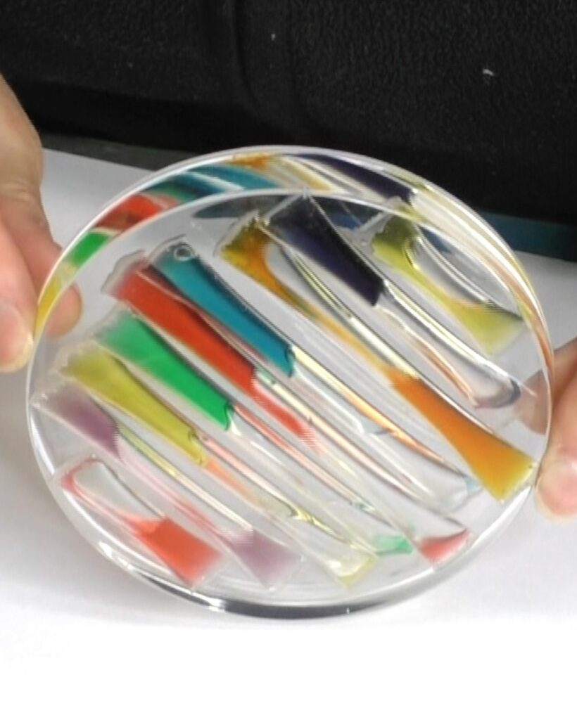 Liquid rainbow resin coaster tilted to the side