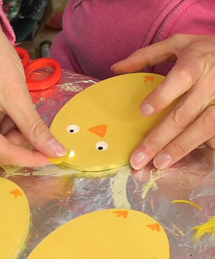 Add a small feather to the drop of glue to the top of the chick head