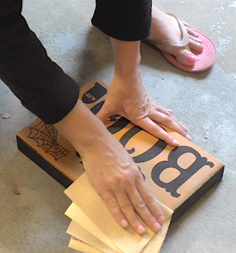 Sand the edges of the Halloween sign for a distressed and worn look