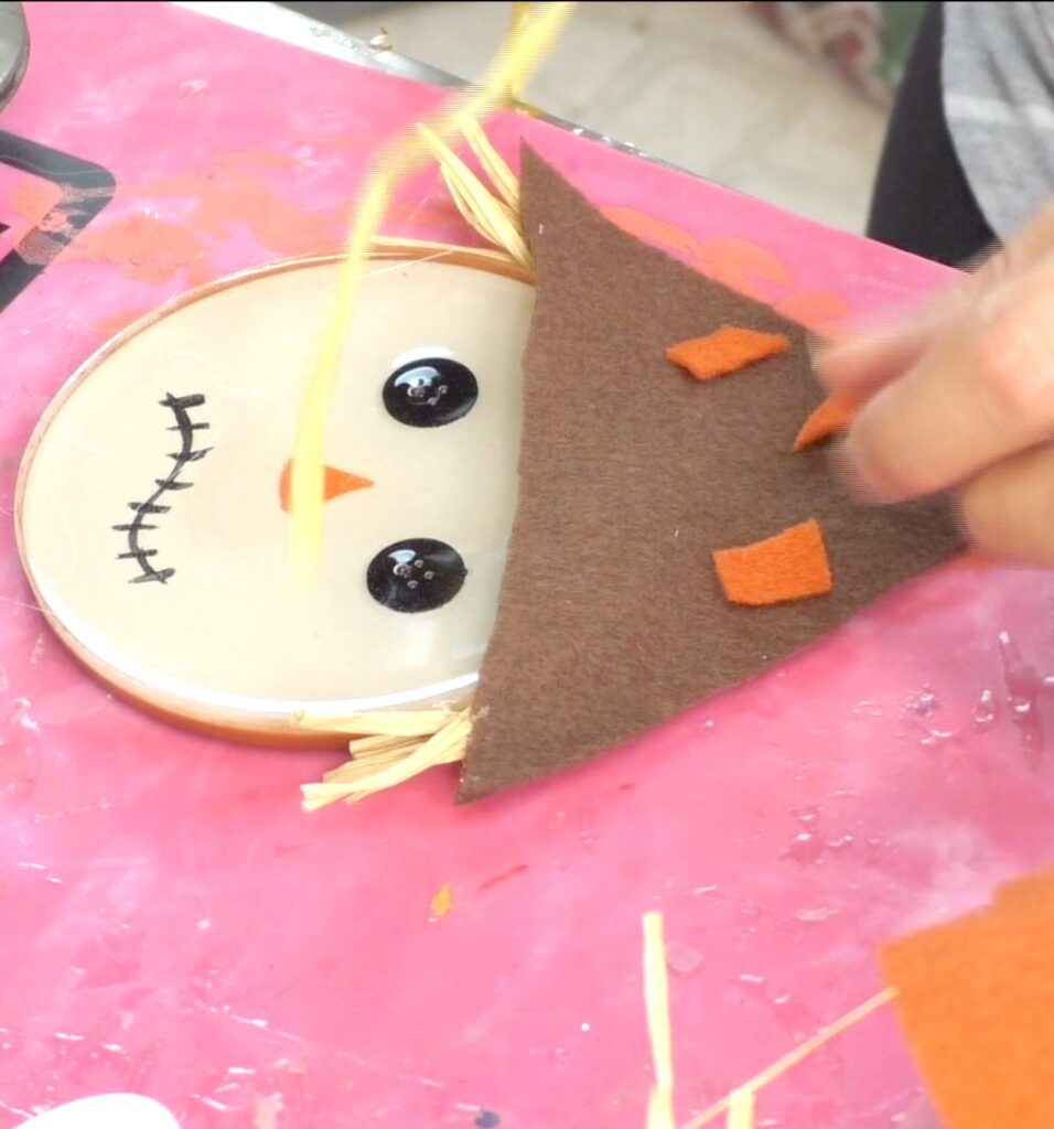 Glue on orange patches to the scarecrow hat