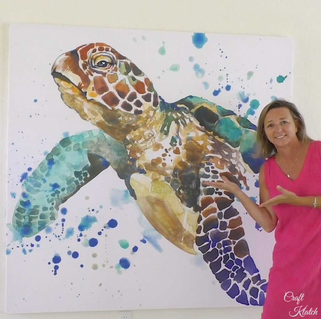 Sea turtle large wall art hanging on a wall with Mona standing next to it