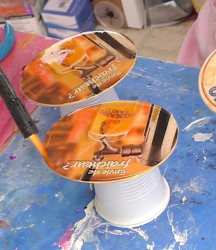 Use lighter to pop resin on cardboard coasters