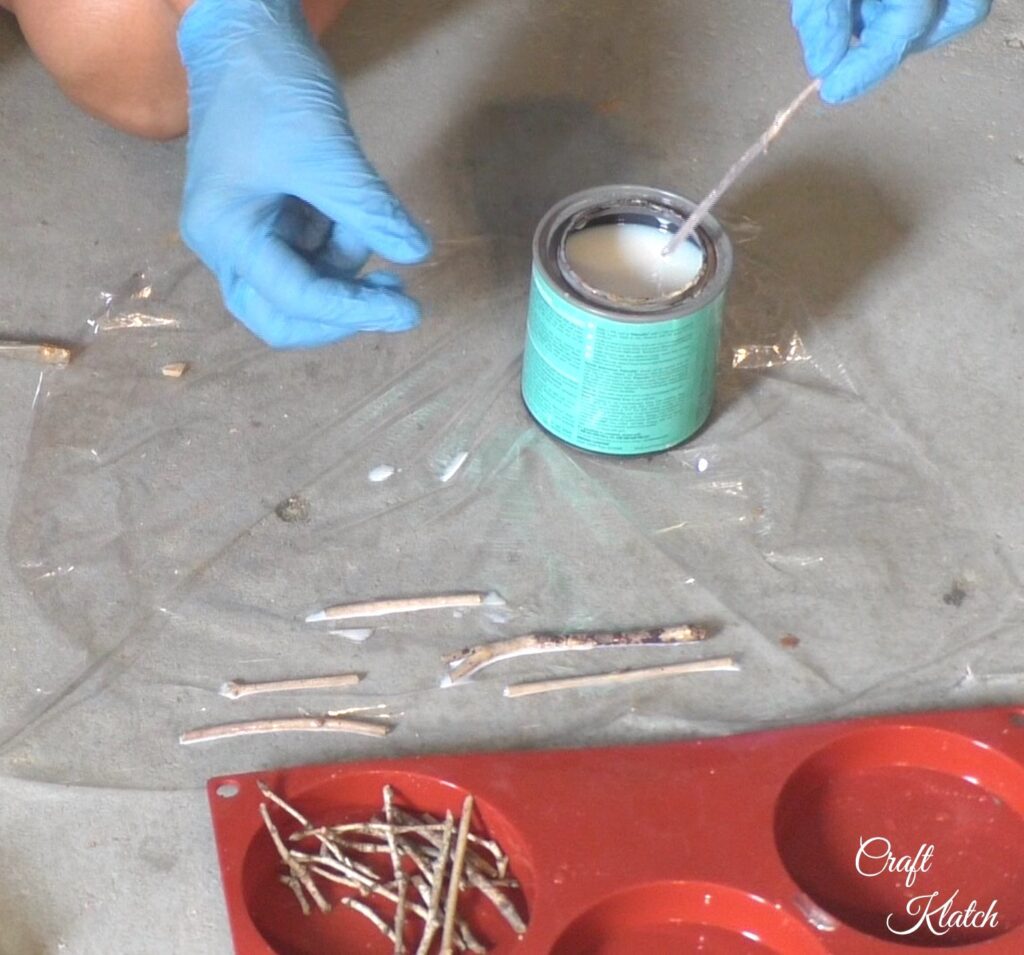 Dipping twigs in varnish and laying them on plastic