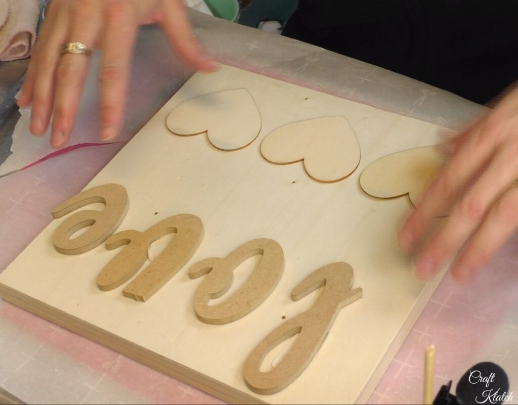 Plan the love sign with the letters and hearts on the plaque