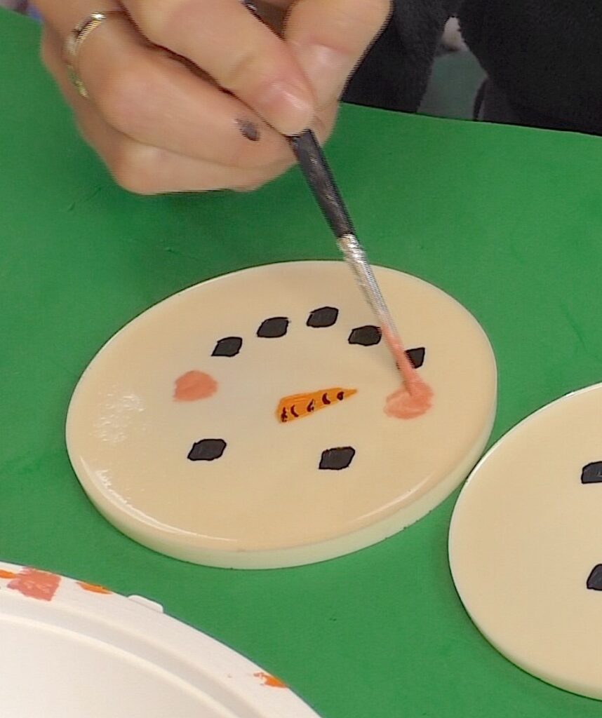 Paint faces onto the resin snowman craft