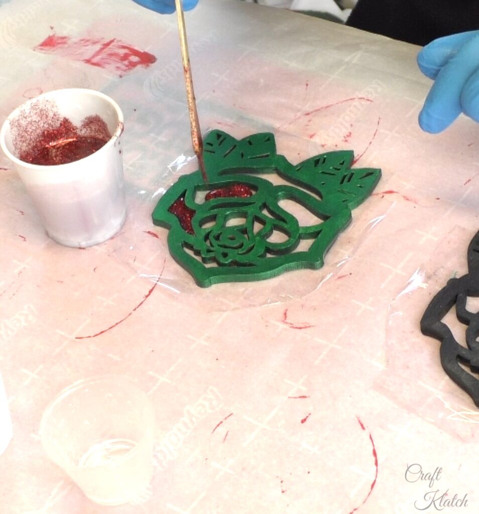 Drip red glitter resin into the wood rose coaster