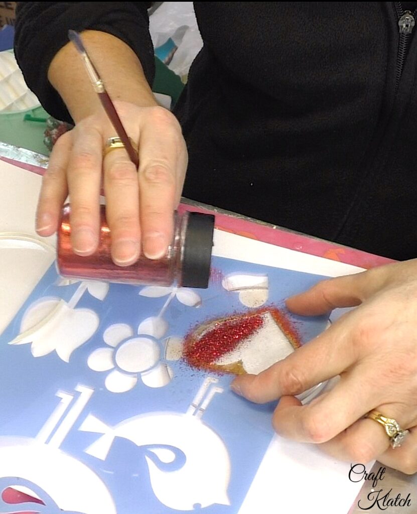 Pour fine red glitter onto the stenciled heart